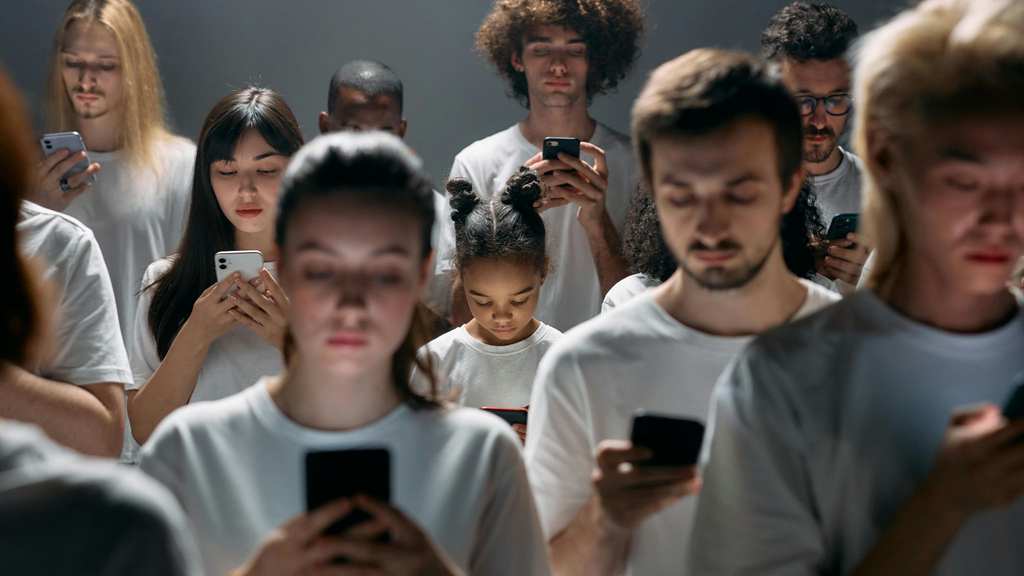 A diverse group of people engrossed in their smartphones, highlighting modern social connectivity.